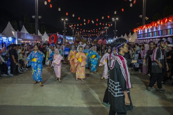 夜の提灯の下、浴衣での盆踊り